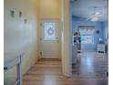 Bright entryway with light wood floors and view of adjacent room at 2549 Buttonwood Run, The Villages, FL 32162