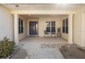 Inviting front porch with decorative columns, seating, and a blue front door with glass detailing at 26709 Augusta Springs Cir, Leesburg, FL 34748