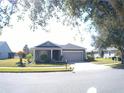 Single-story home with gray exterior, two-car garage, and landscaping at 314 Salt Marsh Ln, Groveland, FL 34736