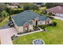 Aerial view of single-story house with green roof and landscaped yard at 39248 Tacoma Dr, Lady Lake, FL 32159