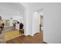 Hallway with wood floors, view of bathroom and living areas at 4348 Tuscaloosa Path, The Villages, FL 32163