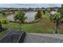 Landscaped backyard with a lake view and screened enclosure at 5078 Lawler Loop, The Villages, FL 32163