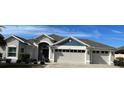 Two-story house with a three-car garage and landscaping at 5078 Lawler Loop, The Villages, FL 32163