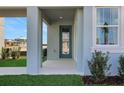 View of the front door and porch area of the house, featuring manicured landscaping at 5221 Blanket Flower St, Apopka, FL 32712