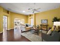 Bright living room features hardwood floors, comfortable seating, and a view into the dining area at 526 Kingston Way, The Villages, FL 32162