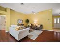 Living room with hardwood floors, neutral walls, and view into the kitchen and dining area at 526 Kingston Way, The Villages, FL 32162