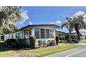 Beautiful home exterior featuring lush green lawn, mature trees and convenient golf cart parking at 534 Palo Verde Dr, Leesburg, FL 34748