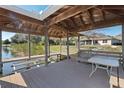 A covered dock extends to the water, featuring a table, bench seating, and an electric boat lift at 6026 Landings Blvd, Lady Lake, FL 32159