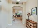 Inviting foyer with tile flooring, an archway leading to the living room, and a charming side table at 16814 Se 80Th Bellavista Cir, The Villages, FL 32162