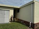 Exterior home detail showcasing the utility storage, vinyl siding and brick foundation at 188 Hibiscus Way, Leesburg, FL 34748