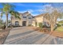 This home boasts a double-entry front door, brick driveway, and well-maintained landscaping at 3463 Creek Run Ln, Eustis, FL 32736