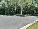 Landscaped entryway with a circular driveway and lush trees at 4813 Waters Gate Dr, Tavares, FL 32778