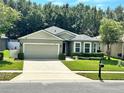 House exterior featuring a two-car garage and well-manicured lawn at 4813 Waters Gate Dr, Tavares, FL 32778