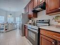 Modern kitchen features stainless steel appliances, wooden cabinets, and a breakfast bar at 5812 Ansley Way, Mount Dora, FL 32757