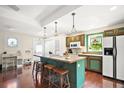 Kitchen with teal cabinets, island, and hardwood floors at 7206 Earlwood Ave, Mount Dora, FL 32757