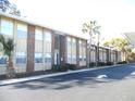Brick condo building with palm trees and parking at 723 Perkins St # 104, Leesburg, FL 34748