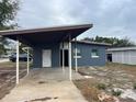 Gray house with carport and mature trees at 1121 Oakland Dr, Tavares, FL 32778