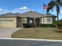 Well-maintained single-story home with a two-car garage, lush lawn, and inviting front entrance at 12163 Se 176Th Loop, Summerfield, FL 34491