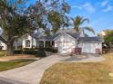 Single-story home with a two-car garage and lush landscaping at 1307 Lopez Ln, The Villages, FL 32159