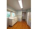 Simple kitchen with light wood floors and vintage cabinets at 1420 Old Mount Dora Rd, Eustis, FL 32726