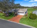 Single-story home with driveway and golf course view at 1711 Lilly Ln, The Villages, FL 32159