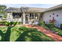 Front entry with walkway, screened porch, and landscaping at 1711 Lilly Ln, The Villages, FL 32159