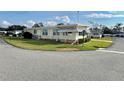 Side view of a yellow single story home with a well manicured lawn at 180 Hibiscus Way, Leesburg, FL 34748