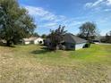 View of the home's back and side, showcasing a large backyard and neighborhood context at 2613 Crest Dr, Haines City, FL 33844