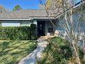 Inviting front entrance with decorative door, lush landscaping, and brick accents at 2613 Crest Dr, Haines City, FL 33844