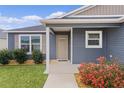 Close up of the front door of a home with neutral colors and simple landscaping at 284 Pelchat Pl, The Villages, FL 32163