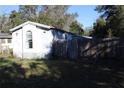 Side view of a mobile home with a wooden fence at 31735 S Lake Dr, Eustis, FL 32736