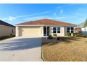 Single-story house with light-yellow walls and a brown tile roof at 3180 Dressendorfer Dr, The Villages, FL 32163