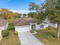 Aerial view of a beautiful single-story home with a two-car garage, manicured lawn, and a peaceful neighborhood setting at 3637 Hawkshead Dr, Clermont, FL 34711