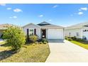 Charming single-story home with a well-maintained lawn and a concrete driveway leading to an attached garage at 3822 Miragalia Ln, The Villages, FL 32163