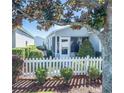 Backyard view of a cozy patio area, white picket fence, and lush landscaping at 433 Aldrich Ave, The Villages, FL 32162