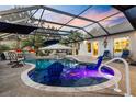 Enclosed pool features comfortable lounge chairs, accent lighting, and a covered bar area for outdoor enjoyment at 4515 Biggs Pl, The Villages, FL 32163