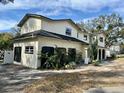 White two-story house with a three-car garage and mature landscaping at 4520 N Hiawassee Rd, Orlando, FL 32818