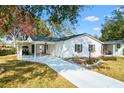 Charming one-story home with a long driveway and carport, located on a well-manicured lawn at 525 Bonita Dr, Lady Lake, FL 32159