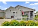 Tan one-story house with white picket fence at 6206 Dingman Way, The Villages, FL 32163