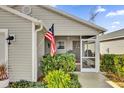 Screened porch with American flag and greenery at 6206 Dingman Way, The Villages, FL 32163