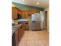 Kitchen features wooden cabinets, black microwave, stainless steel refrigerator, and neutral countertops at 6340 Oren Ct, Apopka, FL 32712