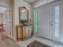 Entryway with tiled floor, antique cabinet, and mirror at 8460 Se 137Th Loop, Summerfield, FL 34491