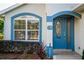 Close-up of front door featuring glass accents and the house number, complemented by tidy landscaping at 85 Golfview Cir, Umatilla, FL 32784