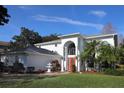 Two-story house with a red door, white walls, fountain, and palm trees at 1001 Willa Lake Cir, Oviedo, FL 32765