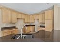 Kitchen with dark countertops and light wood cabinets at 10962 Willow Ridge Loop, Orlando, FL 32825