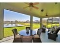 This screened lanai features comfortable seating with views of a tranquil pond at 113 Pecorri Ct, Auburndale, FL 33823
