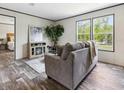 Living room with gray couch and electric fireplace at 11466 Nw 8Th Pl, Ocala, FL 34482