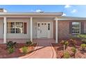 Inviting front porch with decorative columns, a well-maintained walkway, and neatly arranged landscaping at 1320 Cove Pl, Tavares, FL 32778