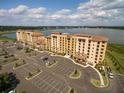 Aerial view of a lakefront building with ample parking at 16300 County Road 455 # 711, Bella Collina, FL 34756