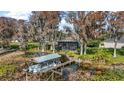 Waterfront home featuring a private boat dock and lift surrounded by lush greenery and mature trees at 1702 N County Road 452, Eustis, FL 32726